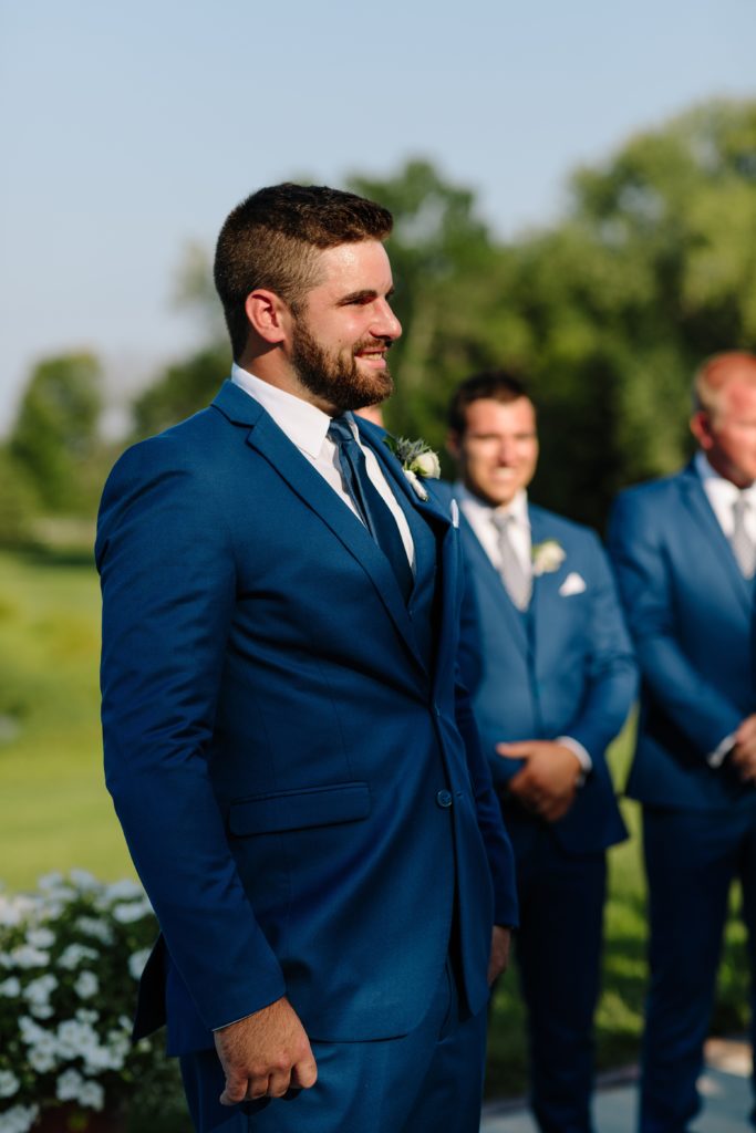 Summer Wedding at Mildale Farm, Natalie Nichole Photography, Kansas City Wedding Photographer, blue and white wedding, anemone, navy, summer wedding color palette, shades of blue, boutonniere, blue suits, generation tux, grooms reaction, outdoor wedding, wedding ceremony outside