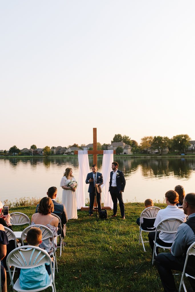 bride and groom get married at their fall wedding ceremony at Raintree Lake in Kansas City during sunset, golden hour elopement