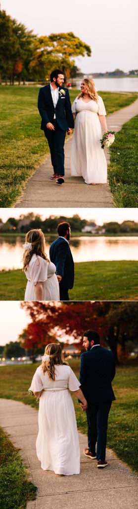 bride and groom walk by the water after their outdoor elopement on raintree lake in lee's summit kansas city in october with the rich fall colors