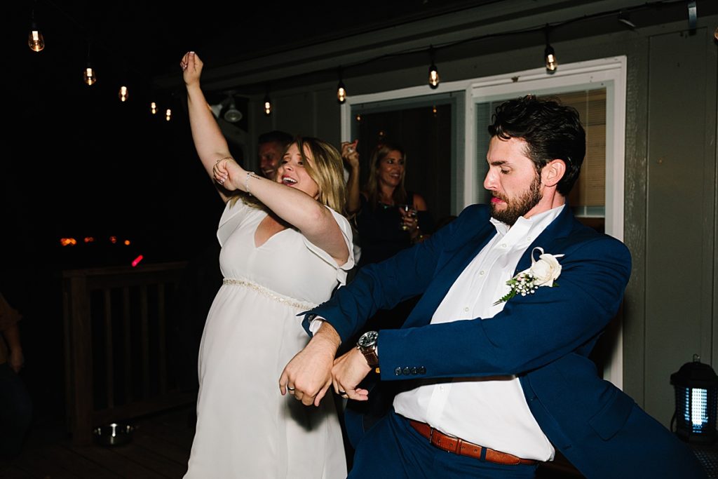 From a Large Wedding to an Intimate Elopement at home bride and groom dancing on the deck in the backyard under twinkle lights in kansas city