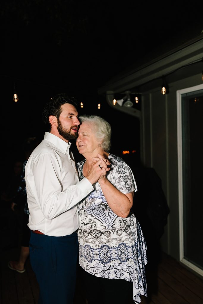 groom dances with his grandma on back deck after at home wedding