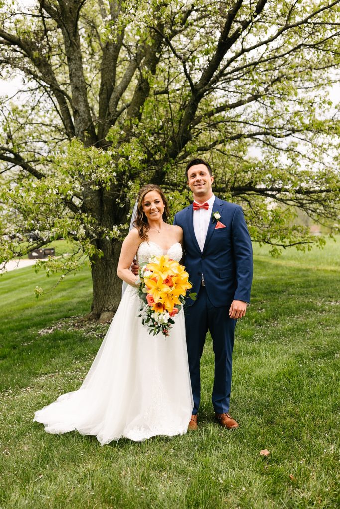 kansas city outdoor wedding, Bliss Plaza Event Venue, kansas city wedding venue, kansas city wedding photographer, morilee wedding dress, bride, strapless wedding dress, navy blue suit, coral bow tie, pink bow tie,