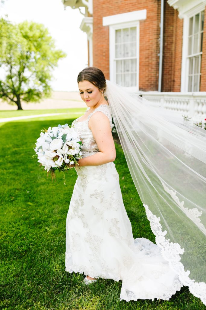 bride wearing Jade by Maggie Sottero wedding dress with lace trim veil