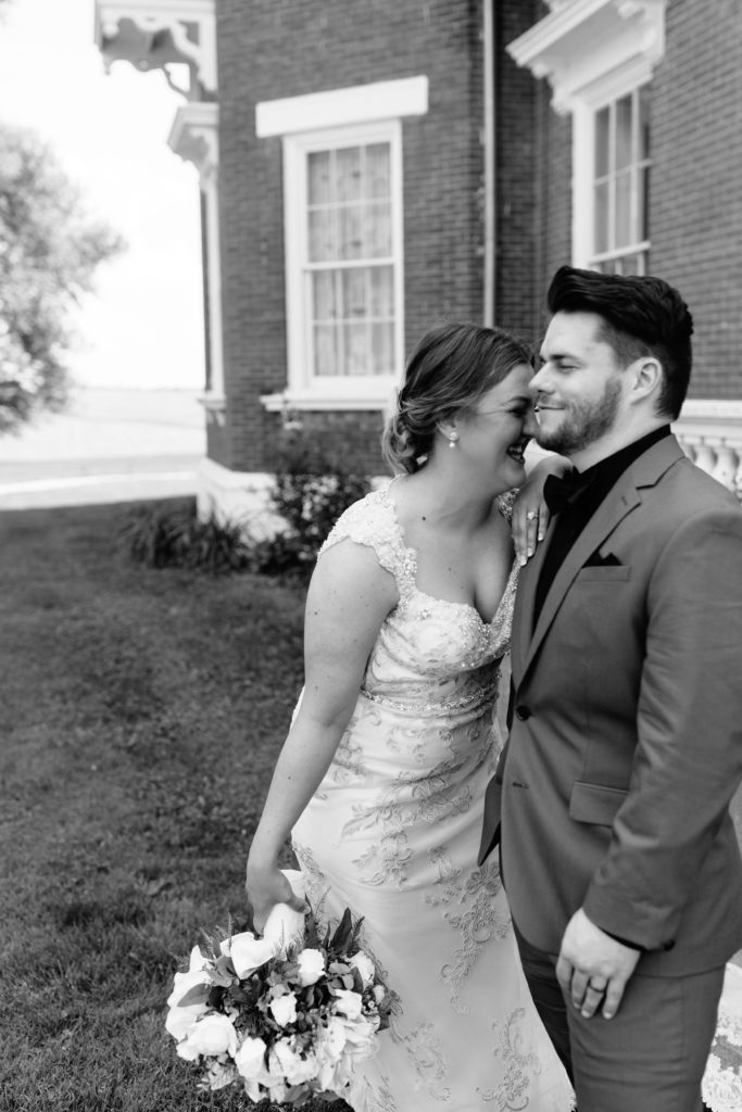 bride and groom laughing. bride wearing Jade by Maggie Sottero wedding dress and groom wearing grey suit with black shirt