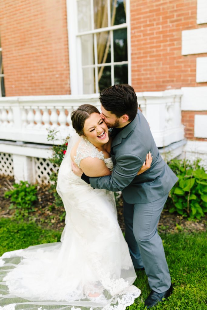 groom kisses brides cheek during wedding photos