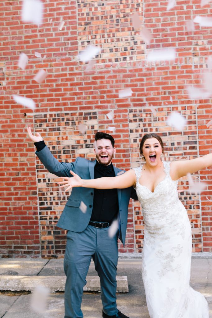bride and groom popping biodegradable confetti poppers on their wedding day