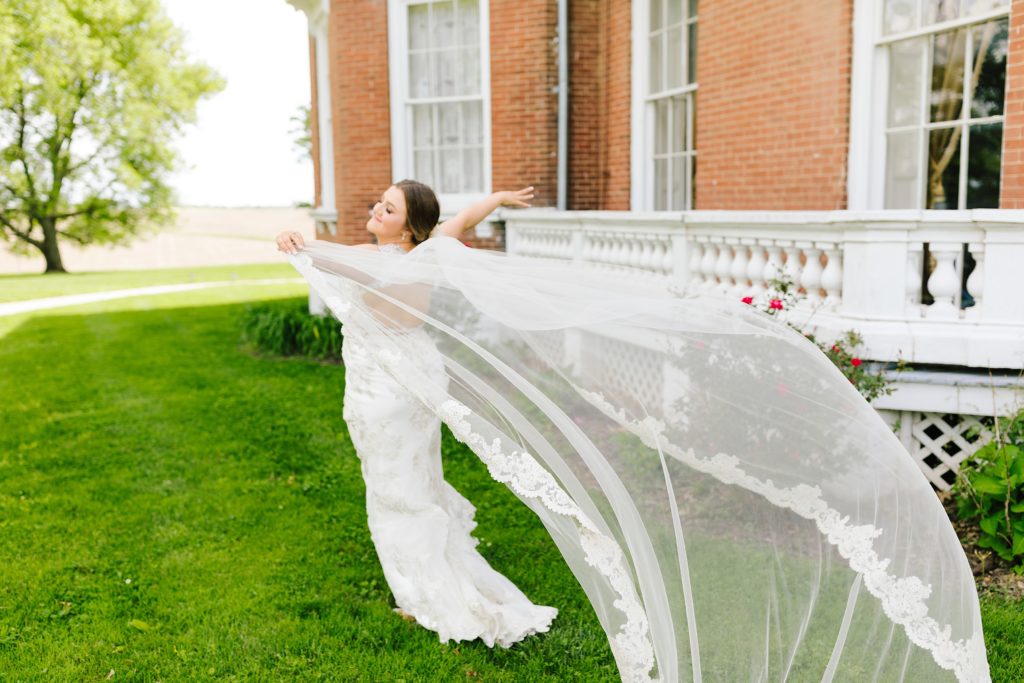 Bride wearing a long lace trim veil with her Maggie Sottero wedding dress