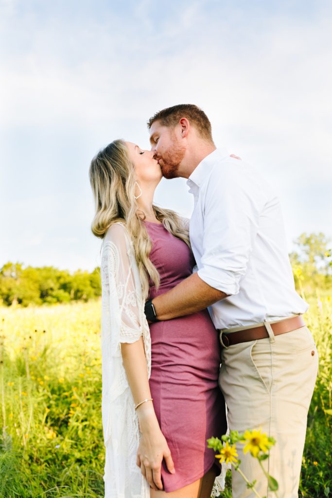 sunrise maternity session at Shawnee Mission Park, Kansas City Photographer, baby announcement, gender reveal, big kiss in a field of wild flowers