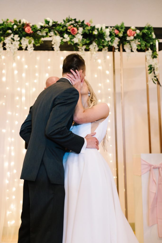 overland park ballroom wedding ceremony, bride and grooms first kiss
