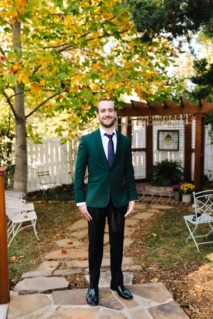 Kansas City groom wearing a dark green emerald green suit and purple tie from The Black Tux