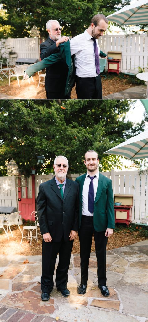 father of the groom helps his son put on his green suit jacket