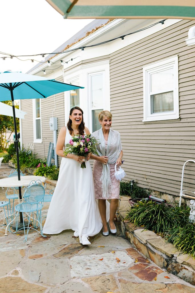 bride walks down the aisle with her mom at her small wedding ceremony