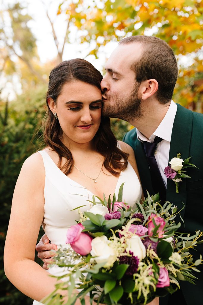 modern bride with a boho bouquet and her groom wearing a dark green suit jacket