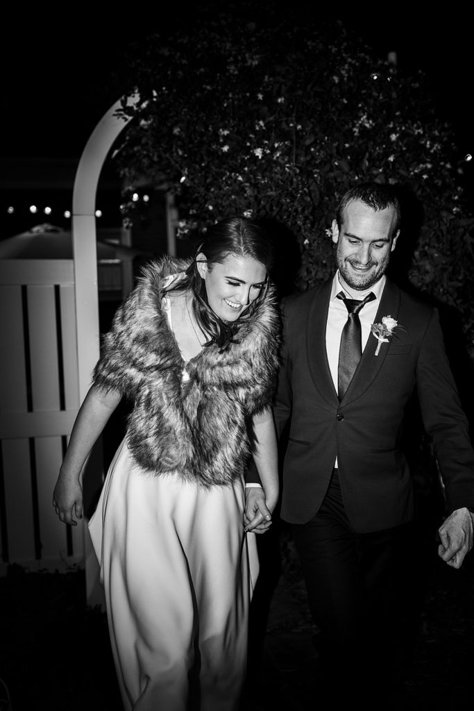 bride wearing a faux fur shawl and leaving the wedding reception like a movie star