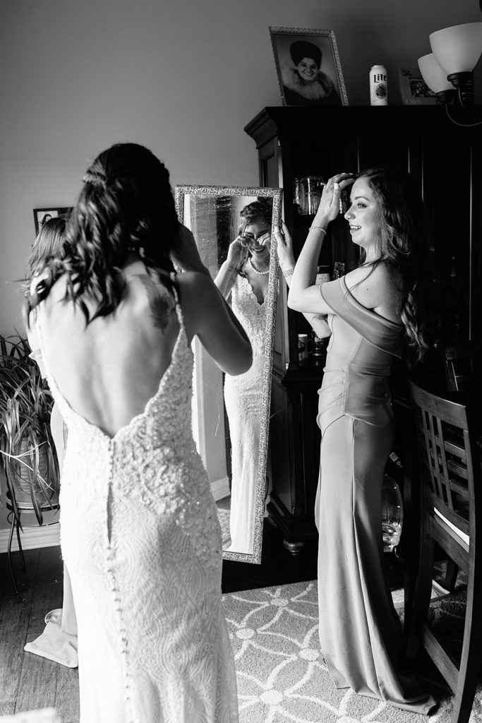 bride and bridesmaids cry when bride sees herself all dressed up in her bridal attire