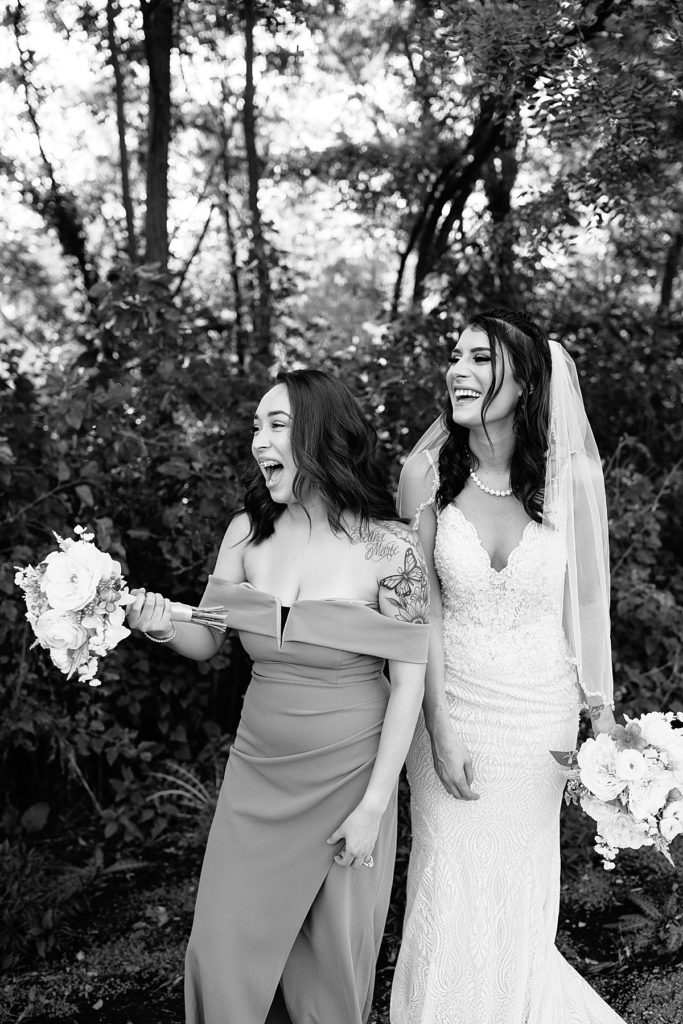 bride and her best friend bridesmaid in candid black and white photo