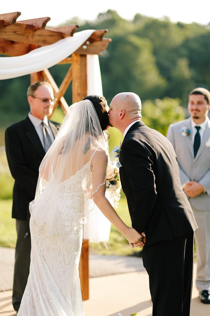 father of the bride kisses her cheek as he gives her away at their wedding ceremony