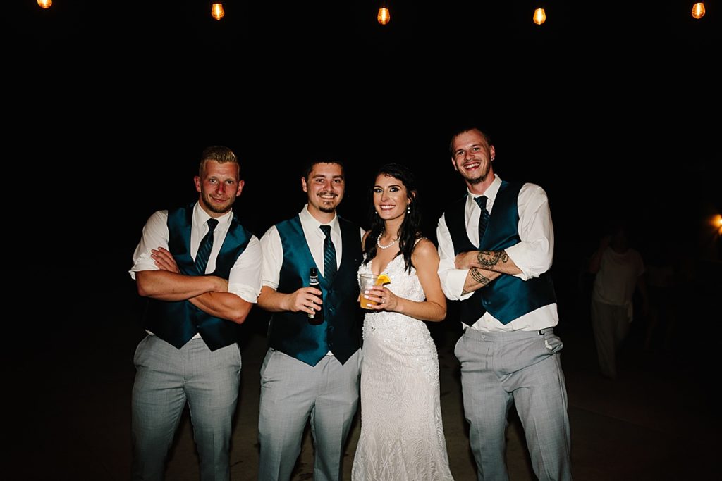 bride and groom with the groomsmen at their wedding reception