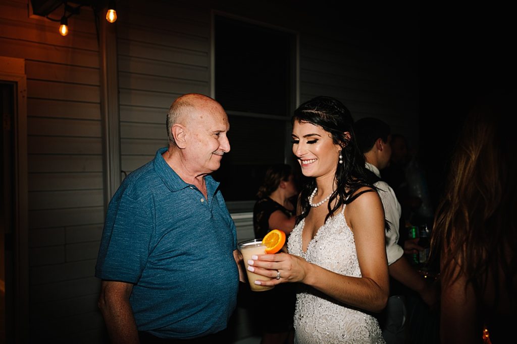 bride and her grandpa laugh at the backyard wedding reception in Kansas City