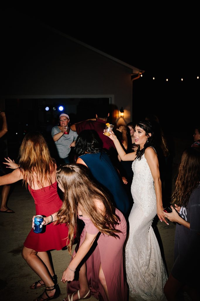 bride on the dance floor with her best friends celebrating during her backyard wedding reception