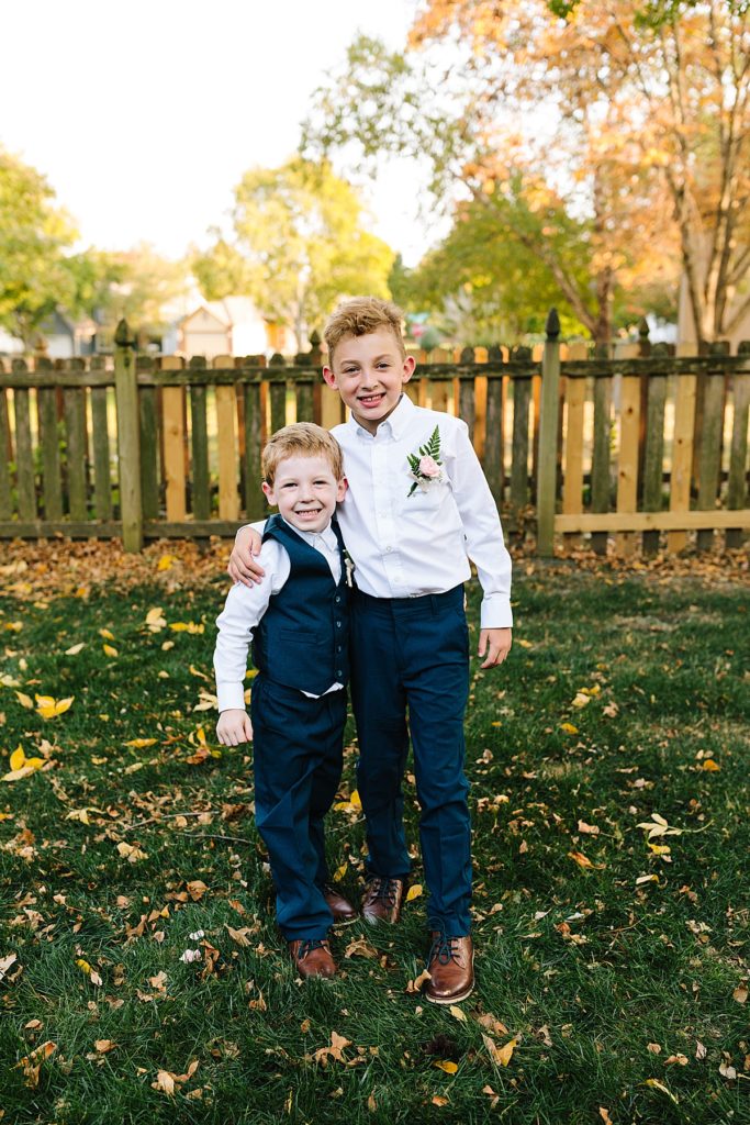 ring bearers wearing navy pants and vests with rose boutonnieres at a fall wedding