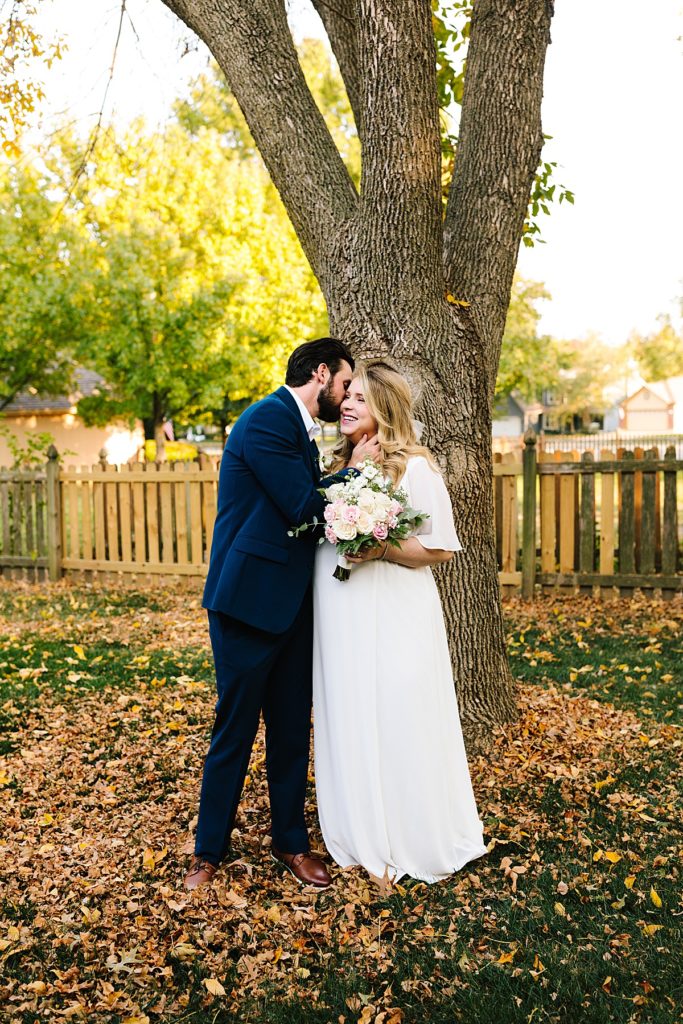 bride and groom at their fall ceremony at Raintree lake before their intimate october elopement, groom wearing a navy suit bride in a flowy dress