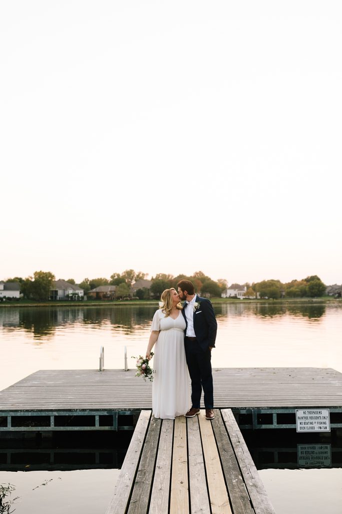bride and groom sunset portraits on a dock after their lake elopement outside near the water in kansas city