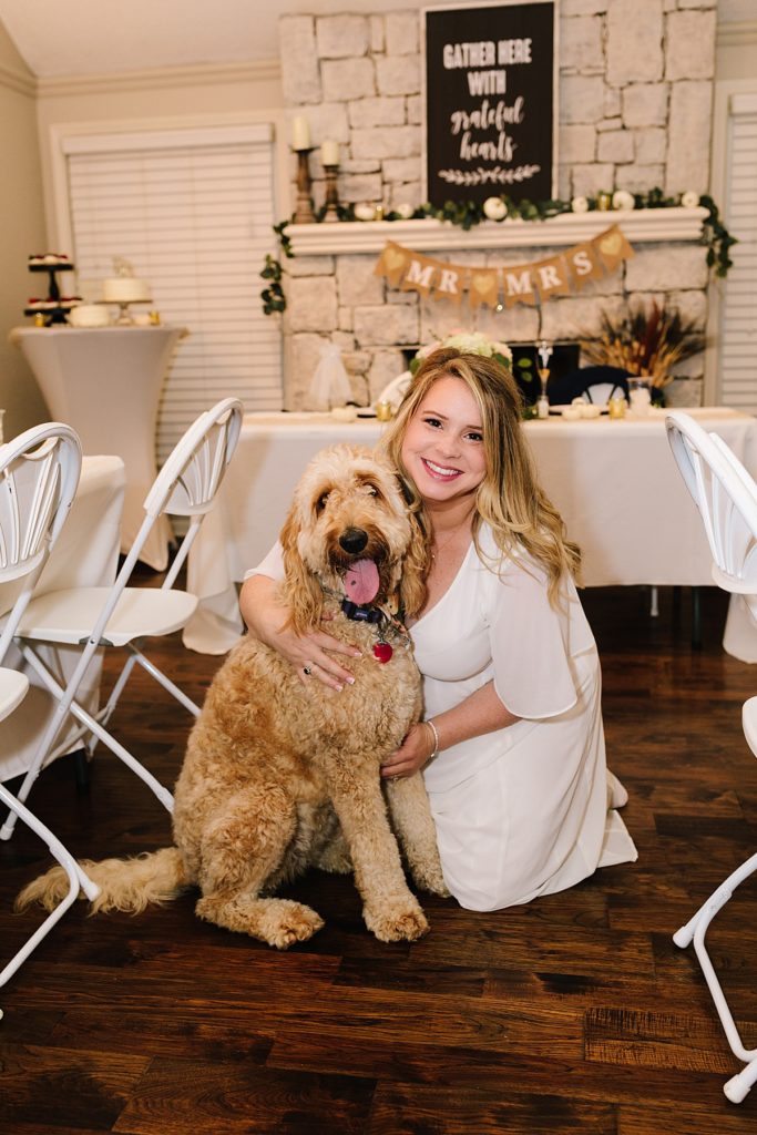 bride with her golden doodle dog after changing from a Large Wedding to an Intimate Elopement at home