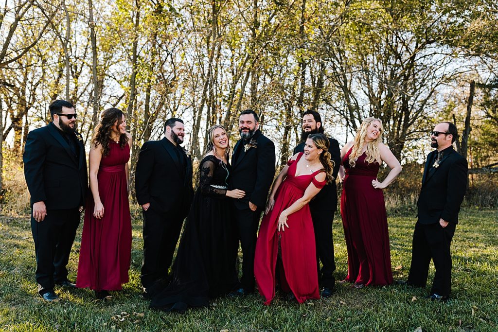 red and black bridal party, groomsmen wearing black suits, bridesmaids wearing red dresses, mix and match bridesmaids