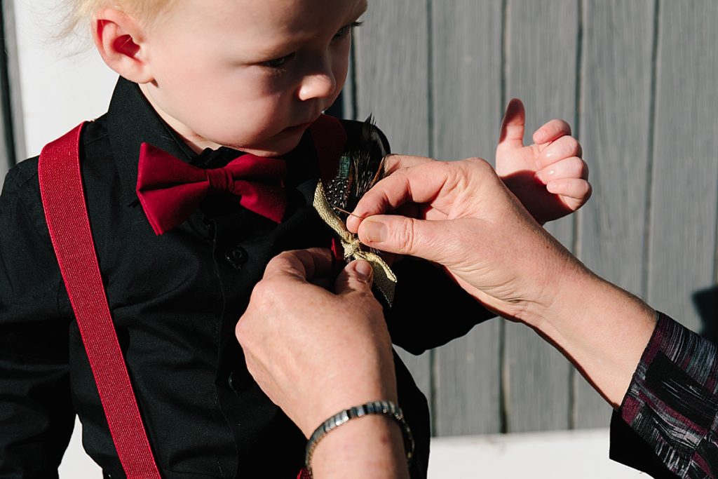 ring bearer in black shirt and red suspenders,