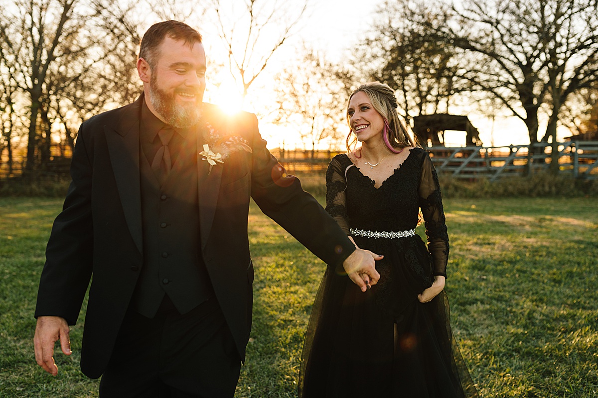 how to have sun flares in photos, halloween wedding, bride wearing lace black wedding dress from amazon with a sparkly belt, groom wearing all black suit with rose boutonniere,