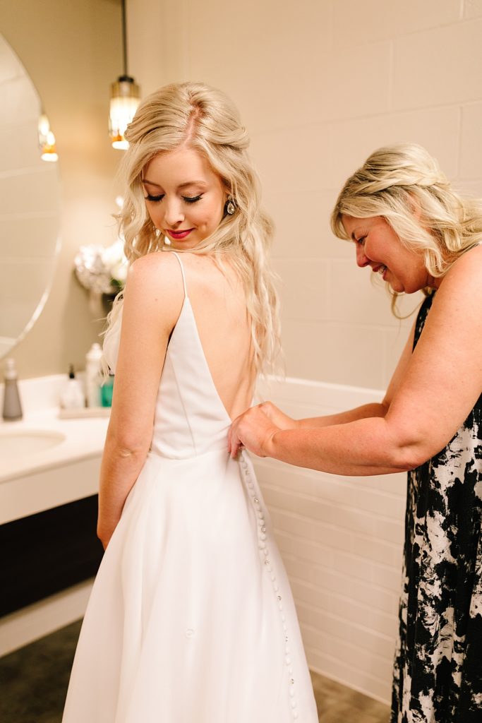 Choosing Your Getting Ready Space: Tips From a KC Wedding Photographer, mother of the bride buttons up brides dress, overland park wedding, kansas city wedding, sleek modern wedding dress, wedding hair, half up half down, wedding make-up