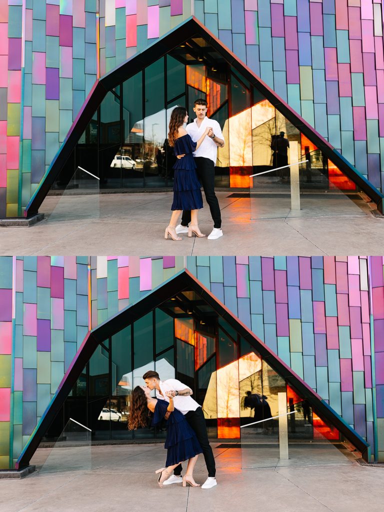 Man and woman dancing in front of a colorful wall. 