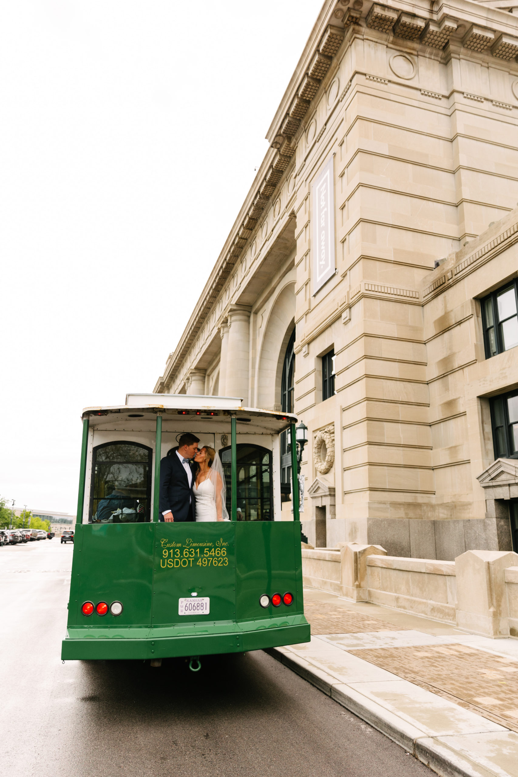 couple uses trolley as wedding day transportation in downtown kansas city, kansas city wedding photographer gives tips on coordinating multiple locations on a wedding day