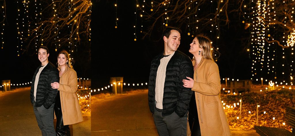 Man and woman posing in front of Christmas lights.