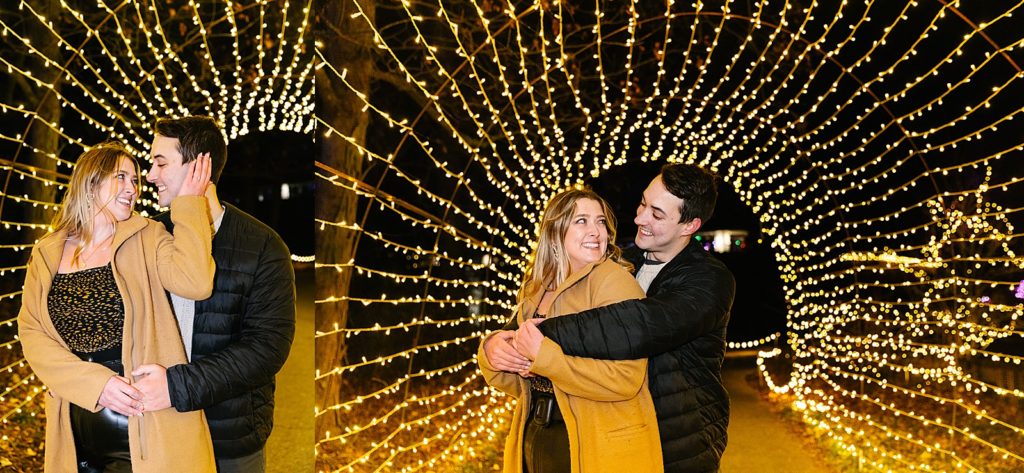 Engaged couple being playful in a tunnel of Christmas lights. 