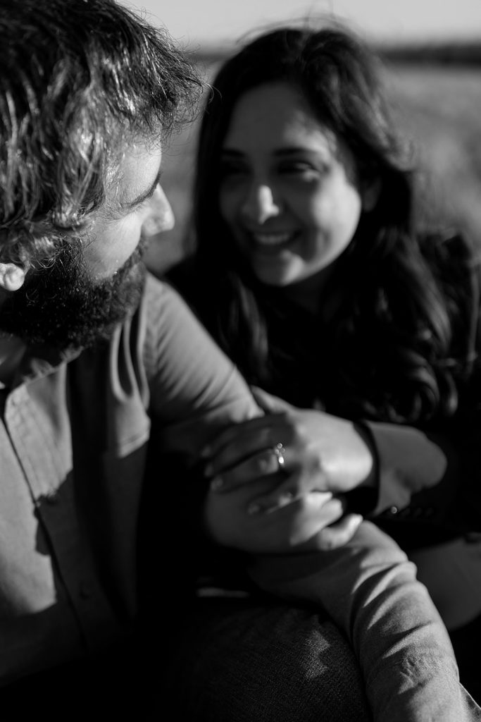 Up close of engaged couple embracing and looking at each other fondly. Black and white image. 