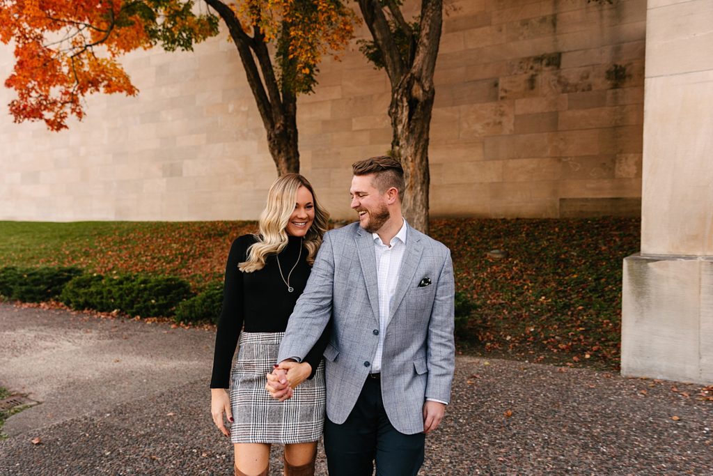 Newly engaged couple walking with Fall foliage in the background. Kansas City Photography. 