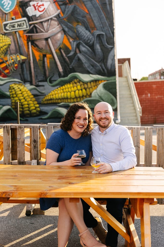 Engaged couple enjoying a beer at a local brewery for their summer engagement session. 