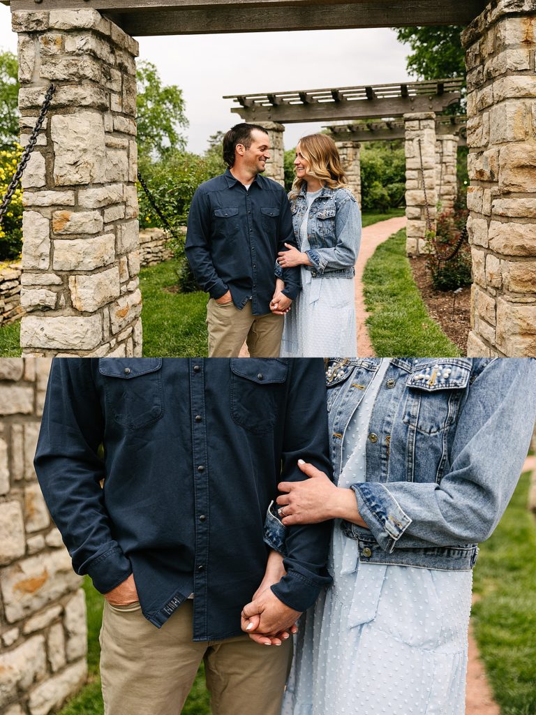 Man in blue shirt and woman in denim jacket holding hands in the middle of a park for their couples photo shoot with KC photographer.