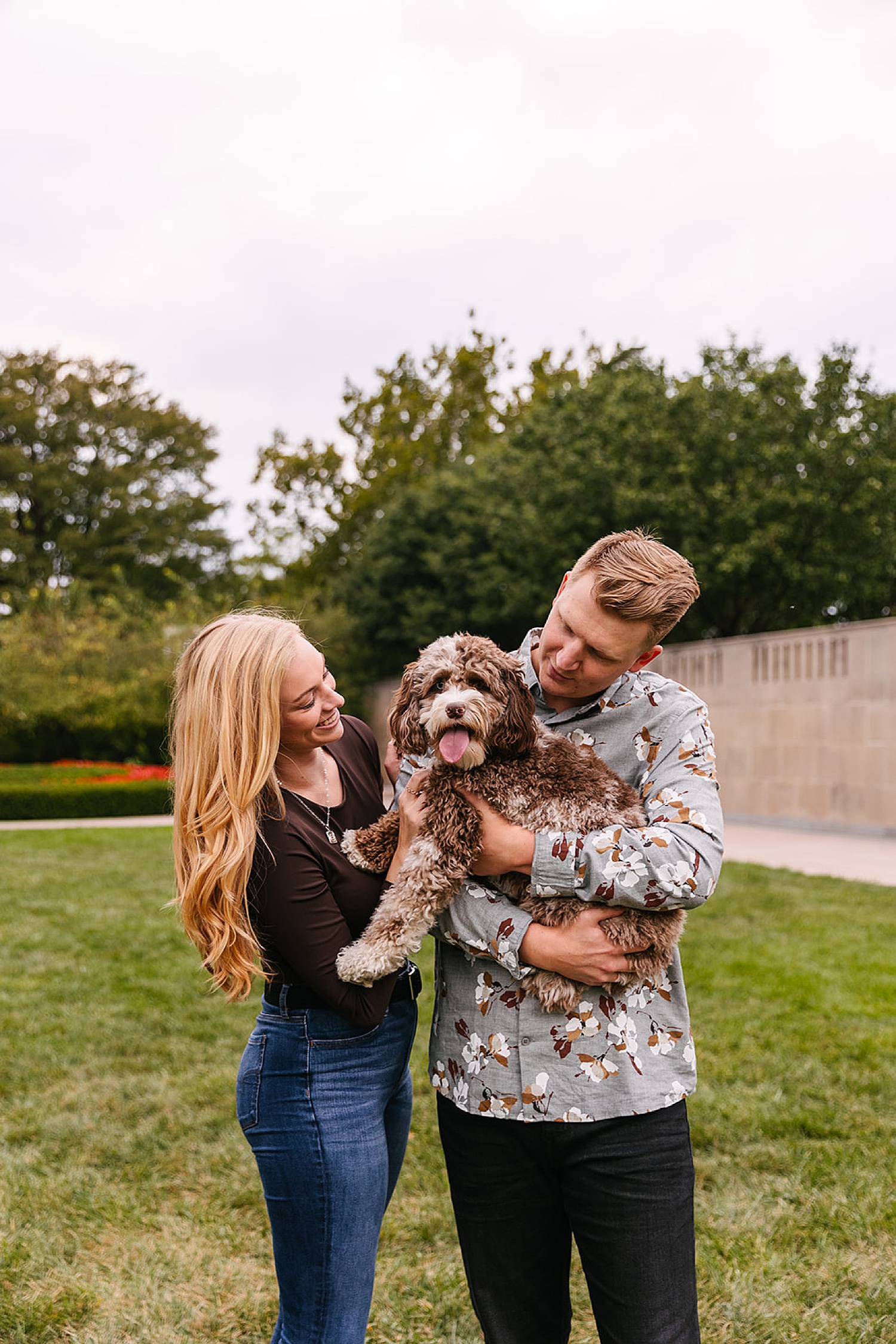 Engaged couple loving their dog during session with Kansas City photographer.