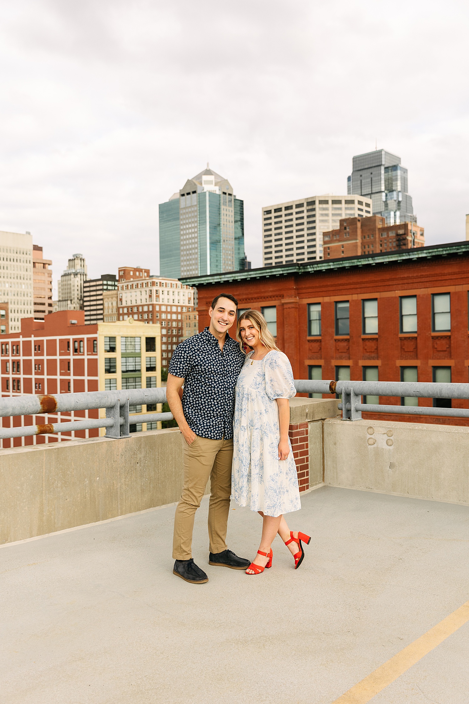 engaged couple standing on Kansas City rooftop with Kansas City photographer 