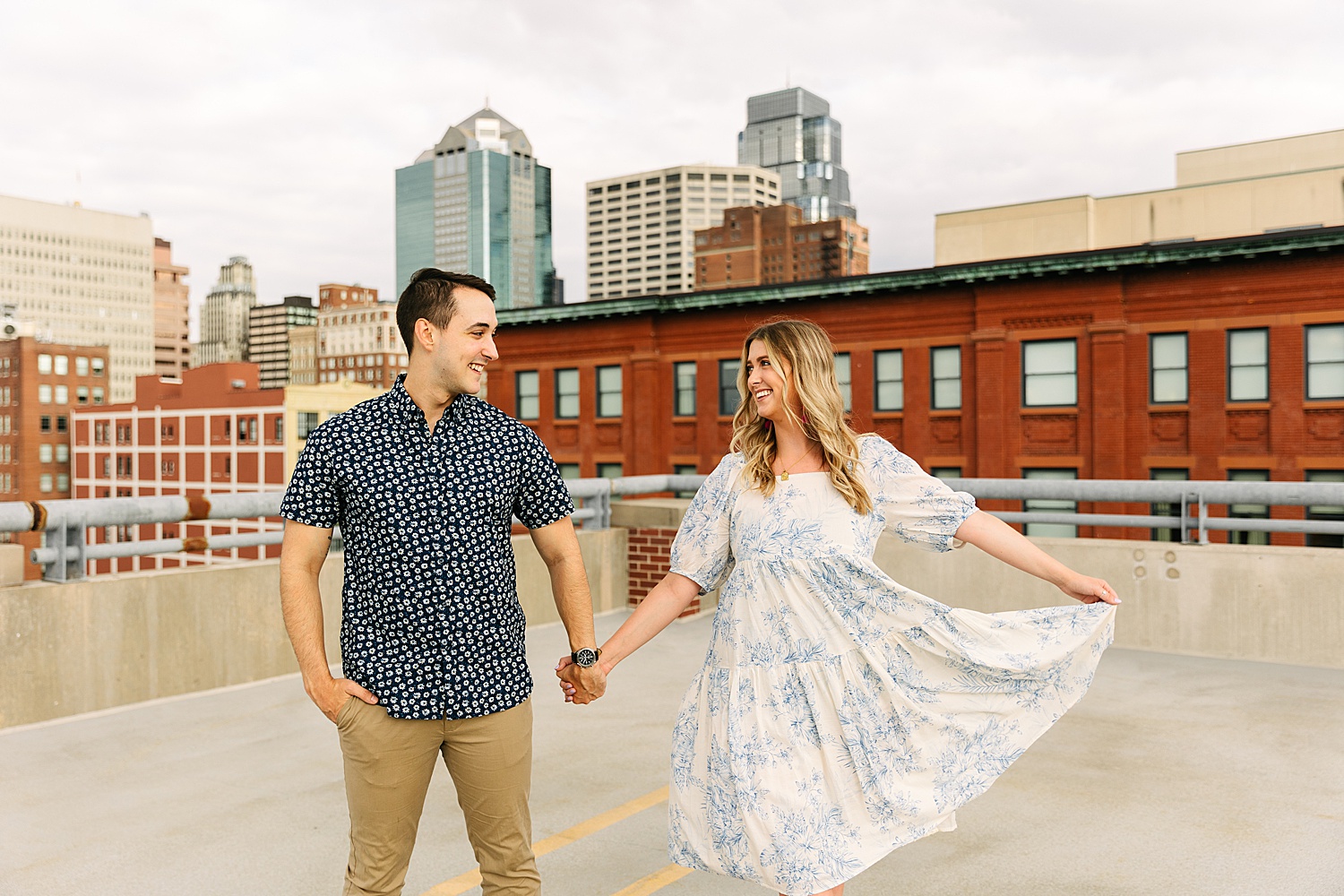 engaged couple holding hands while walking on Kansas City parking garage with engagement photographer