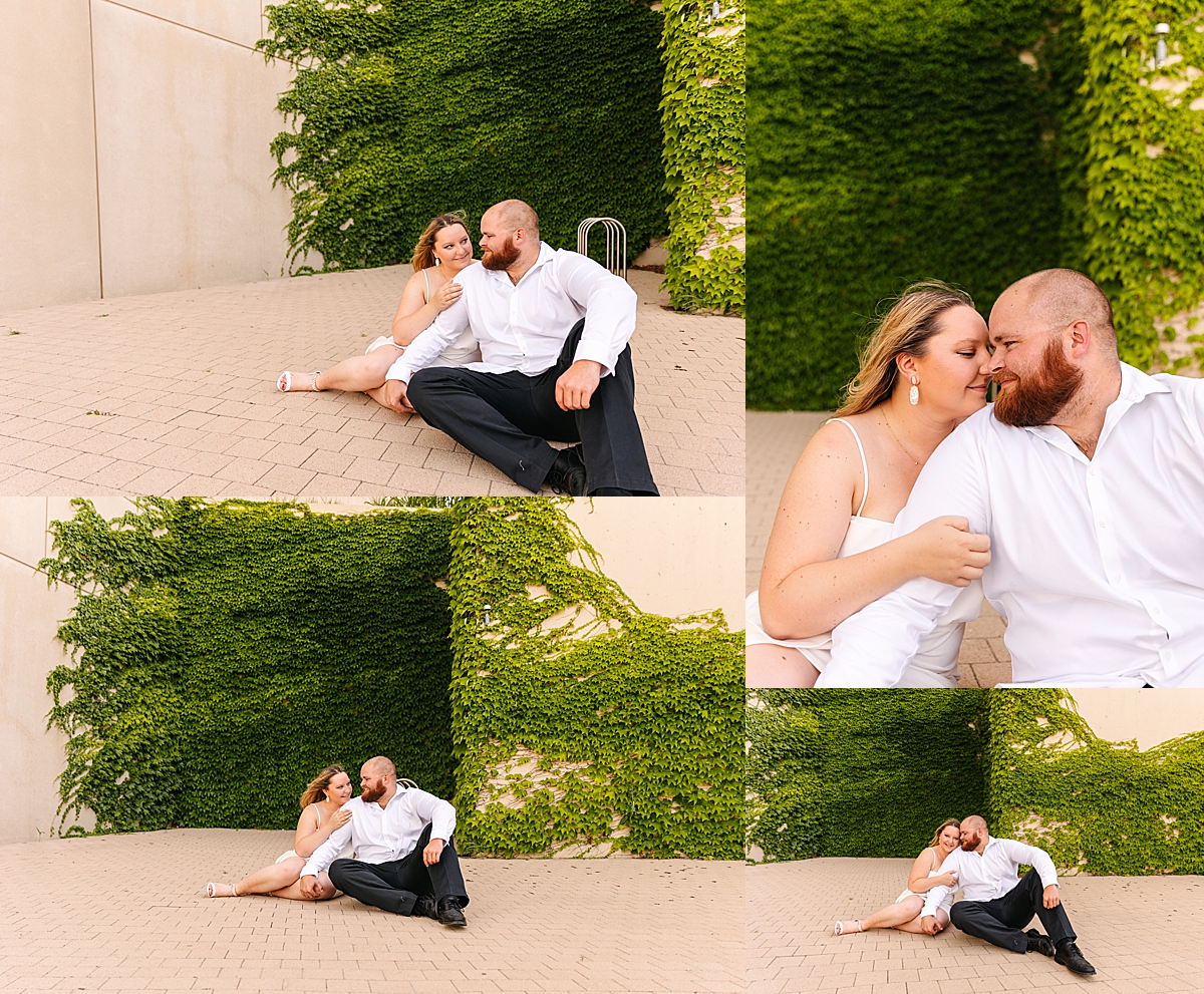 couple all snuggled up during modern engagement session sitting on cement 